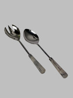 Two silver spoons on a white surface