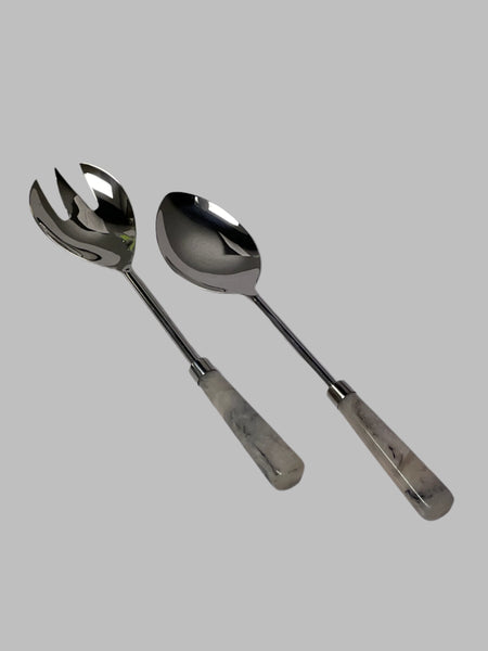 Two silver spoons on a white surface